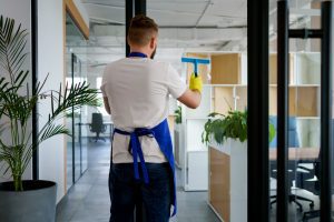professional cleaning service person cleaning office window 300x200